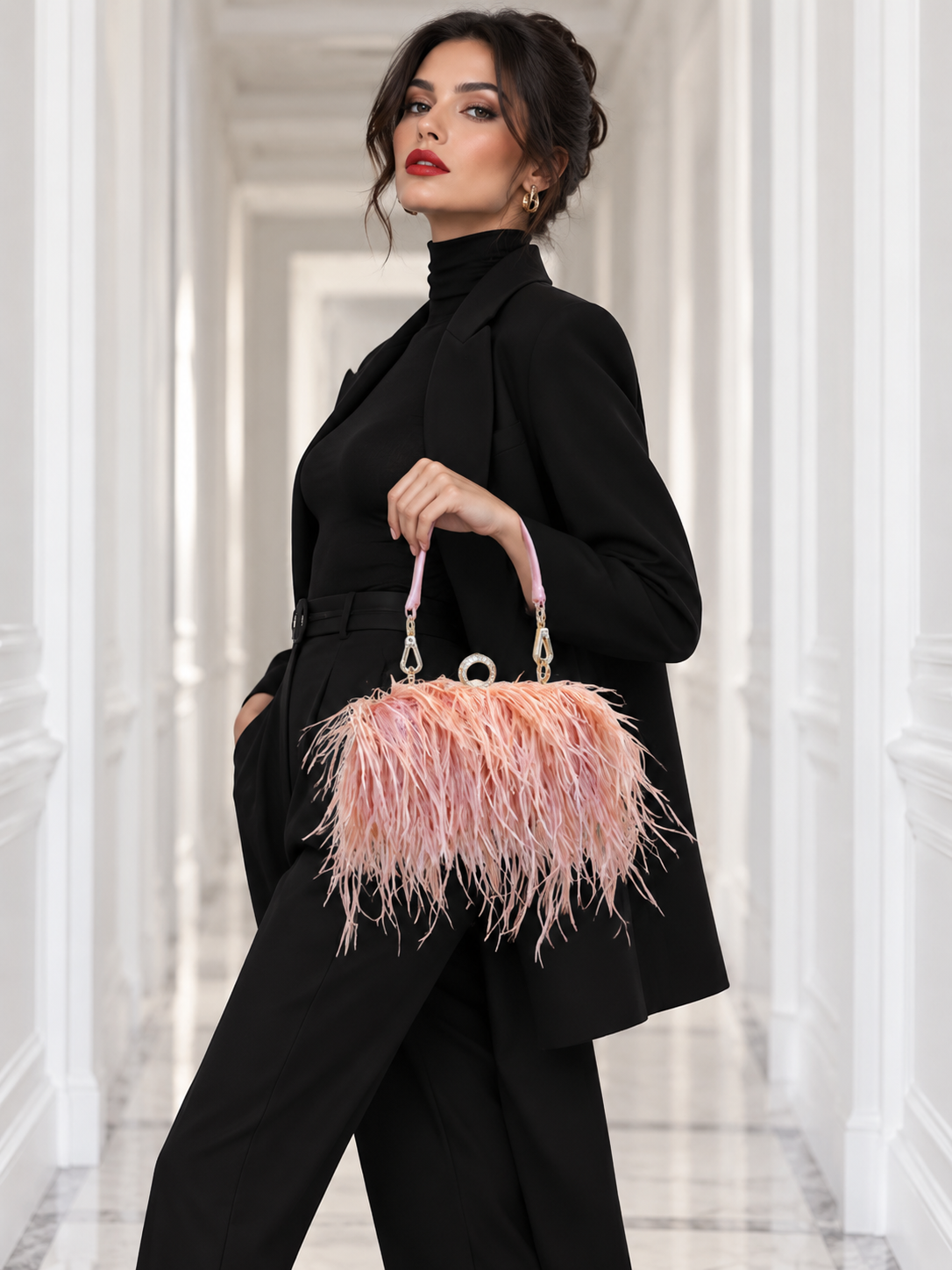 A woman in a black turtleneck and matching trousers holds a pink feathered handbag with a pink handle in a bright white hallway.